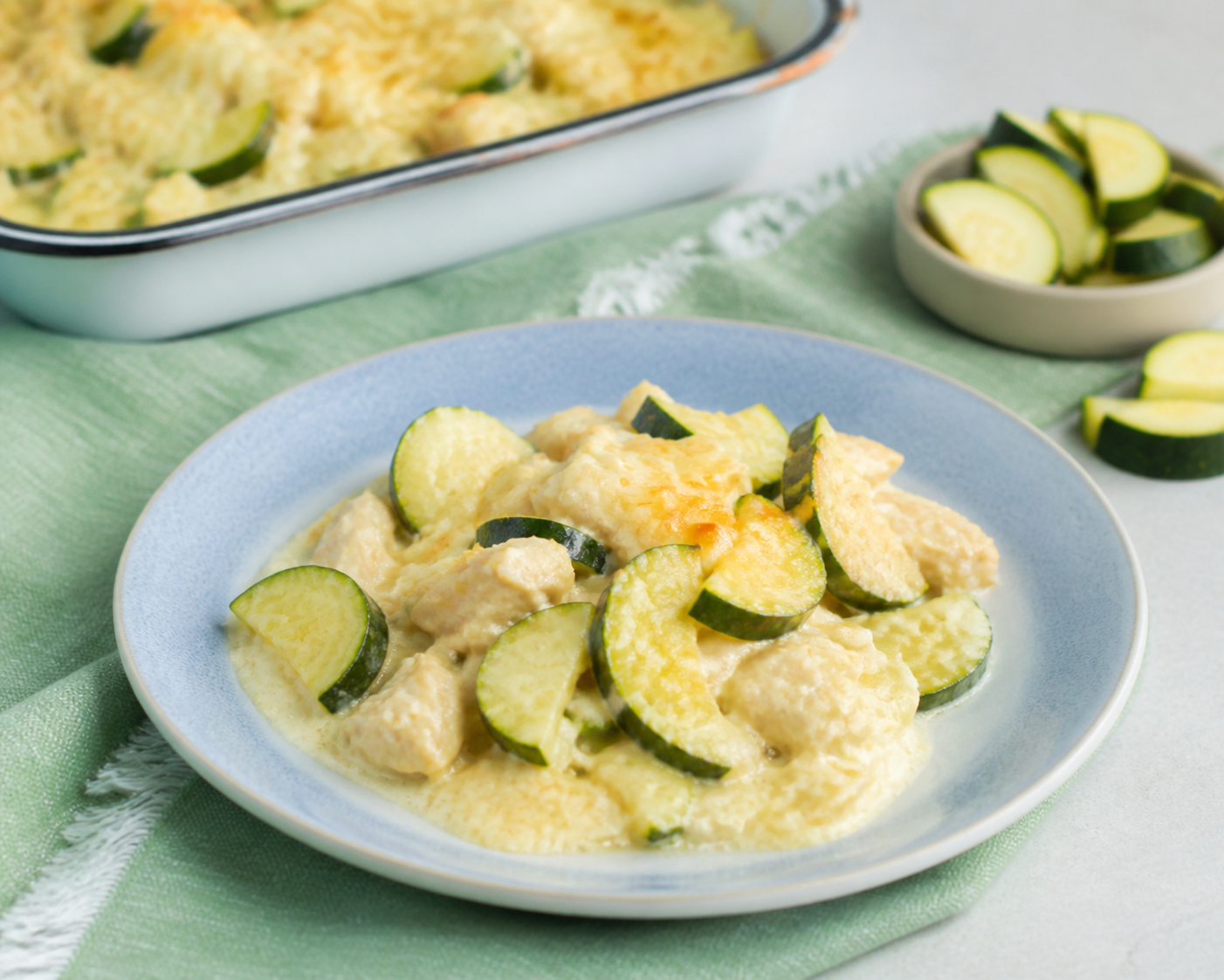 Creamy low-carb chicken and zucchini casserole served on a light blue plate